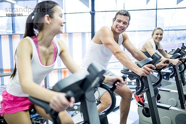 Junge Männer und Frauen trainieren im Fitnessstudio