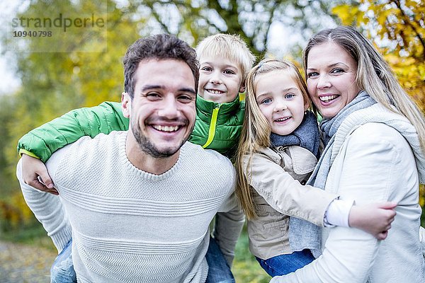 Porträt einer Familie  die sich im Herbst vergnügt
