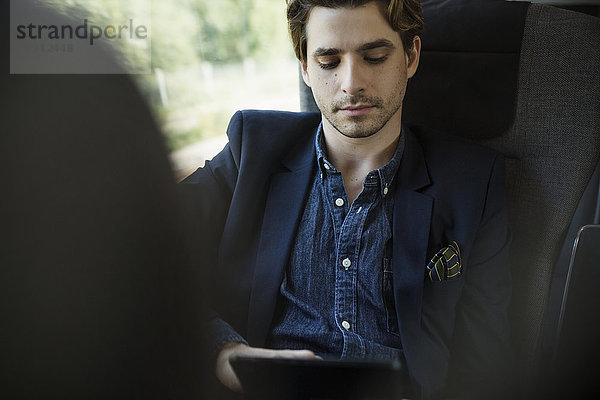 Geschäftsmann mit digitalem Tablett im Zug