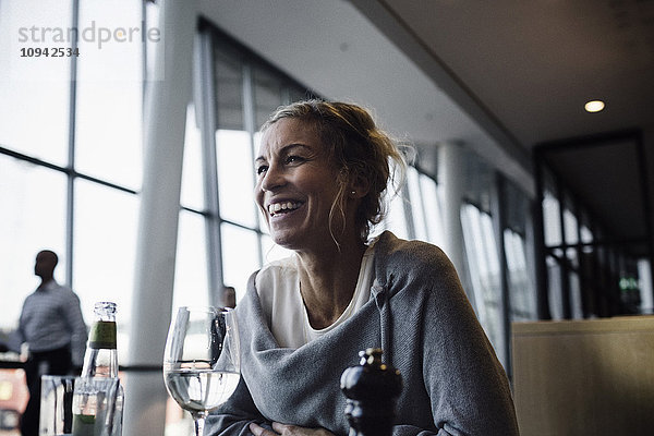 Fröhliche Geschäftsfrau im Café am Flughafen