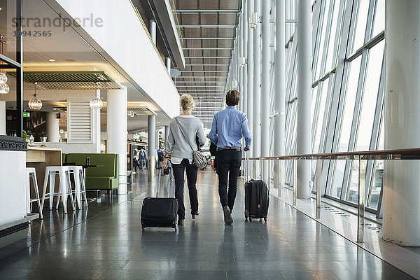 Rückansicht von Geschäftsleuten mit Gepäck am Flughafen
