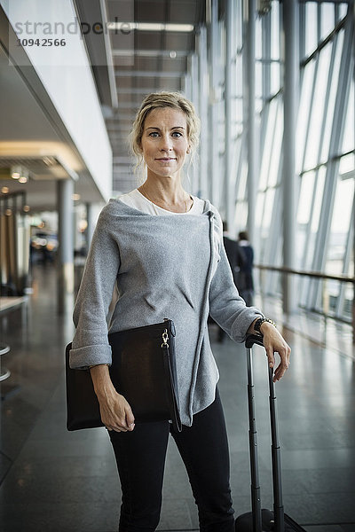 Portrait einer selbstbewussten Geschäftsfrau mit Gepäck am Flughafen