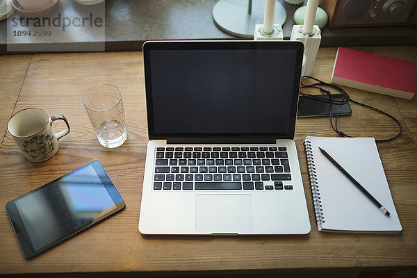 High-Winkel-Ansicht der Technologien mit Notizblock auf dem Tisch im Home-Office