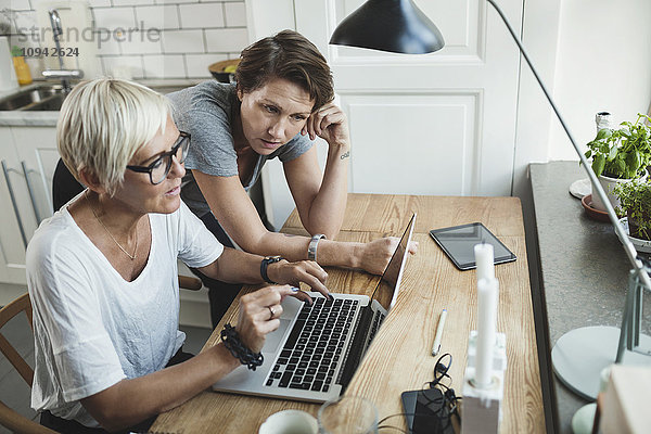 High-Winkel-Ansicht von Produktdesignern  die über den Laptop zu Hause diskutieren.