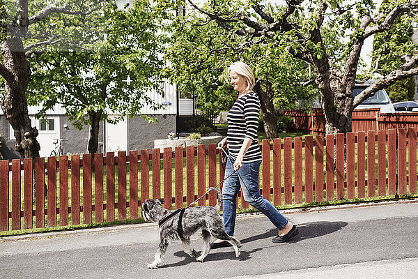 Seitenansicht einer älteren Frau mit Hund auf der Straße