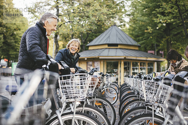 Senioren mit Leihfahrrädern auf dem Parkplatz