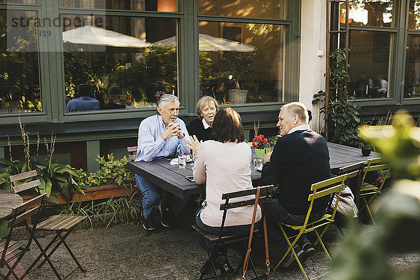 Seniorinnen und Senioren  die sich im Außenrestaurant unterhalten