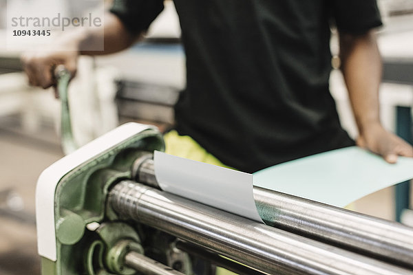 Mittelteil des jungen Schülers mit Maschine in der Werkstatt