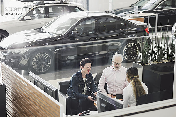 Großer Blickwinkel auf die Verkäuferin bei Kundengesprächen im Autohaus