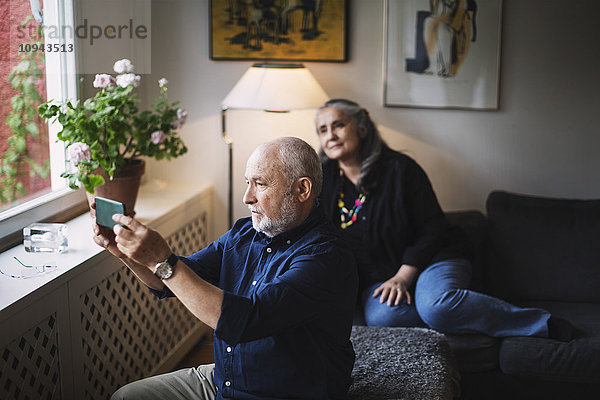 Senior Mann nimmt Selfie mit Frau über Handy mit nach Hause