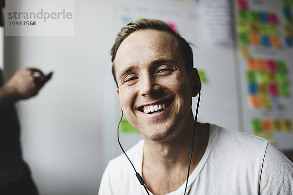 Portrait eines glücklichen Geschäftsmannes mit Kopfhörer im Kreativbüro