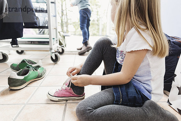 Mädchen mit Schuhen auf dem Boden der Kindertagesstätte