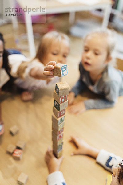 Hochwinkelansicht von Kindern  die mit Blöcken spielen