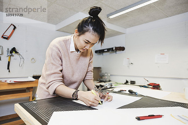 Geschäftsfrau plant auf Papier am Tisch im Kreativbüro
