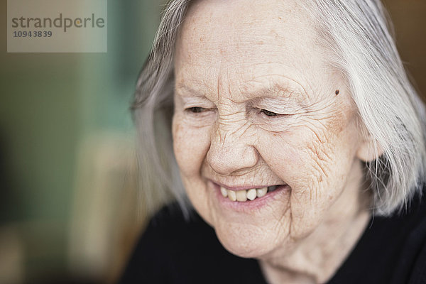 Nahaufnahme einer lächelnden Seniorin im Pflegeheim