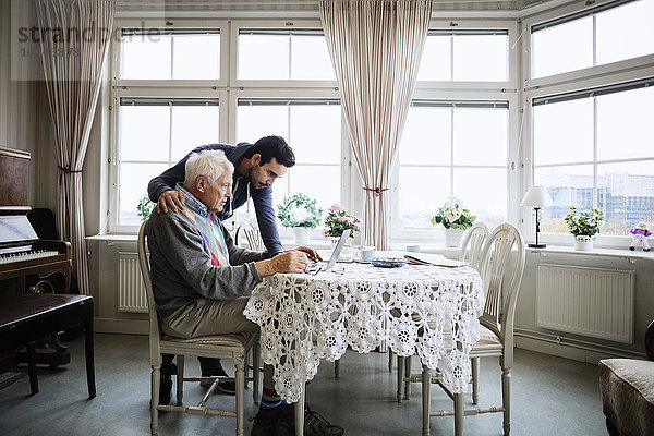 Senior Mann mit Laptop und Hausmeister im Pflegeheim