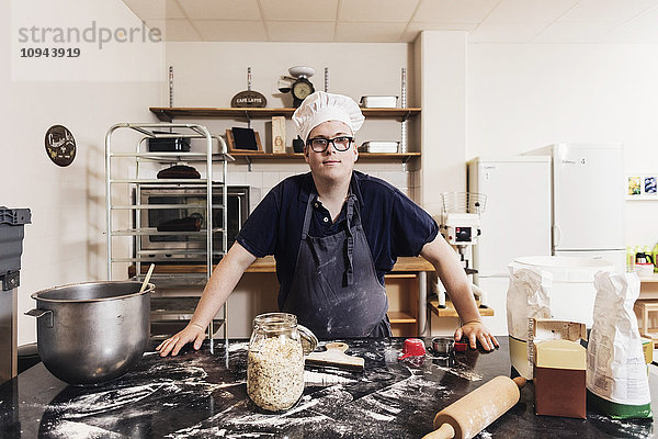 Porträt eines selbstbewussten jungen Bäckers an der Küchenzeile