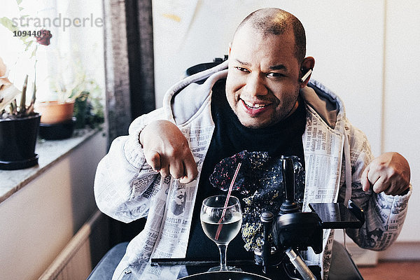 Porträt eines glücklichen behinderten Mannes mit Getränk im Tonstudio
