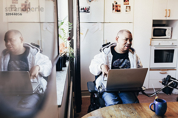 Behinderter Mann mit Laptop im Aufnahmestudio