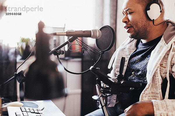 Behinderte männliche Sängerin beim Aufnehmen von Musik im Studio