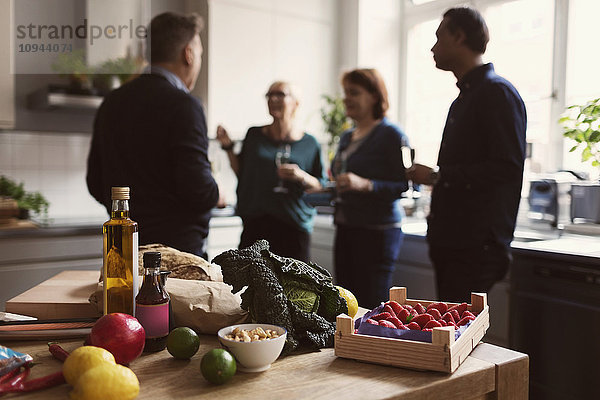 Essen auf dem Tisch gegen Freunde  die in der Küche reden.