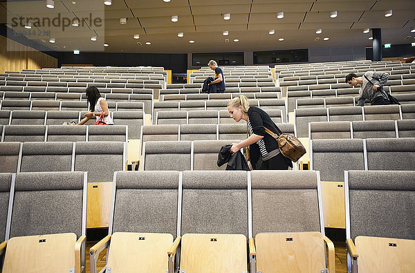 Junge Männer und Frauen verlassen das Auditorium nach dem Seminar