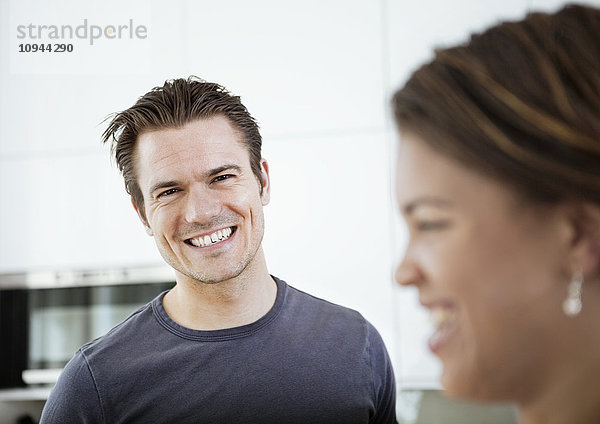 Porträt eines lächelnden erwachsenen Mannes mit Frau im Vordergrund