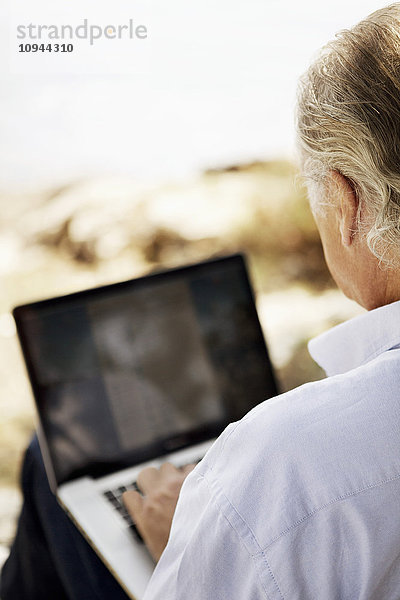 Über die Schulter Ansicht des älteren Mannes mit Laptop im Freien