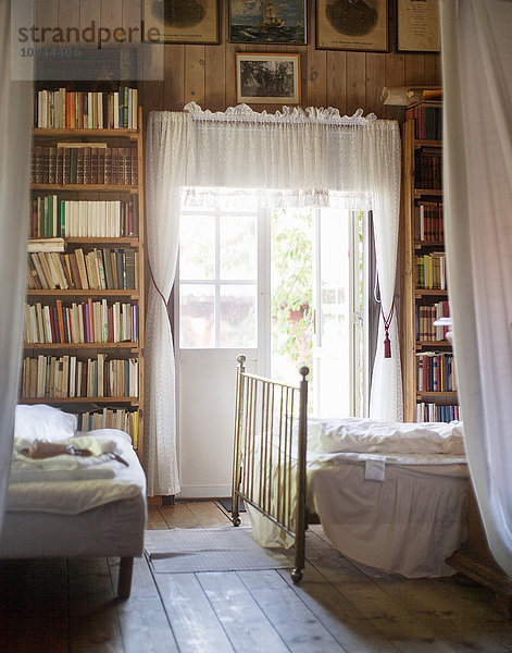 Innenraum eines Schlafzimmers mit im Regal angeordneten Büchern