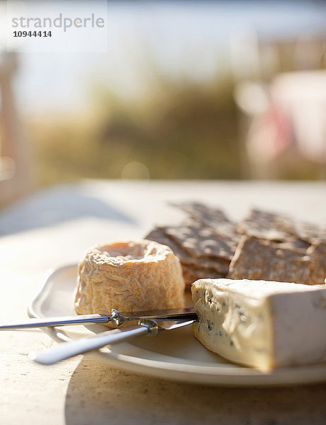 Käse  Waffeln und Buttermesser im Teller auf Holztisch
