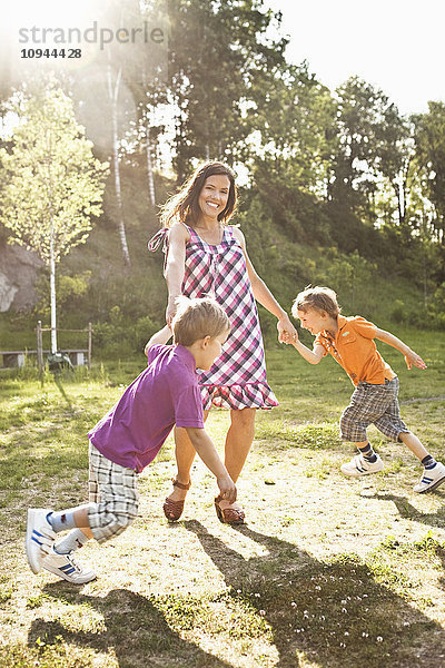 Porträt einer glücklichen Mutter beim Spielen mit Kindern im Park