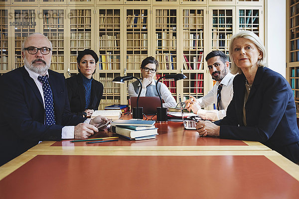 Porträt der Anwälte im Vorstandszimmer gegen das Bücherregal