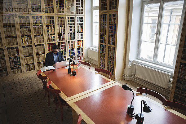 Männliche professionelle Recherche am Tisch in der juristischen Bibliothek