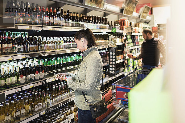 Kundin scannt Bierflasche im Supermarkt