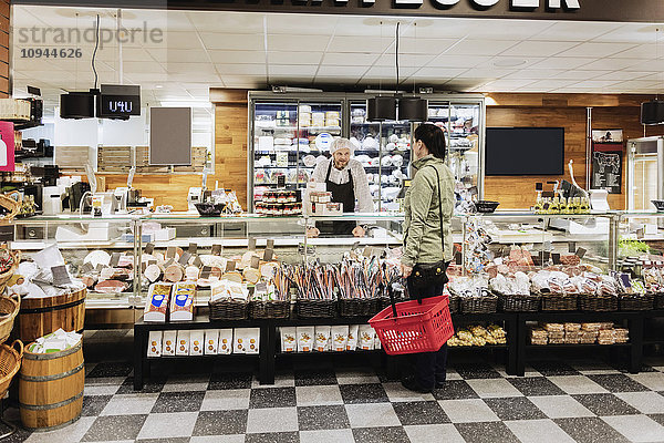 Verkäuferin als Assistentin der Frau im Supermarkt