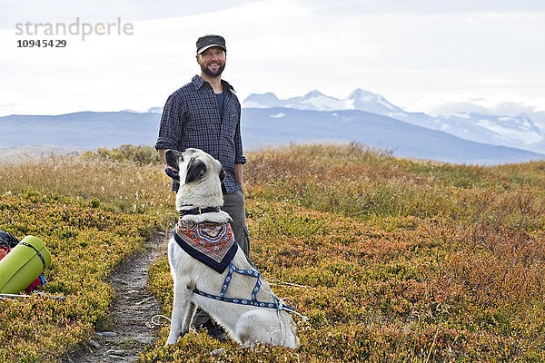 Skandinavien  Schweden  Norrland  Hemavan  Mann wandert mit Hund in den Bergen