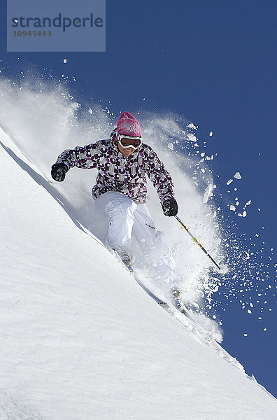 Frau beim Skifahren durch frischen Pulverschnee