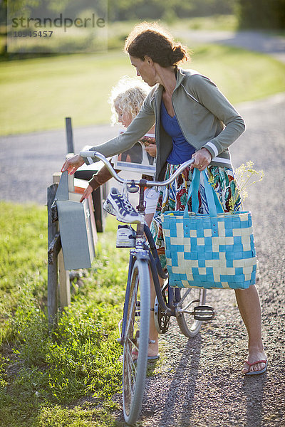 Schweden  Mutter und Tochter (4-5) auf dem Fahrrad bei der Postkontrolle