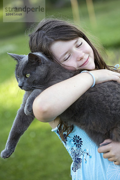 Schweden  Uppsala  Mädchen (10-11) umarmt Katze