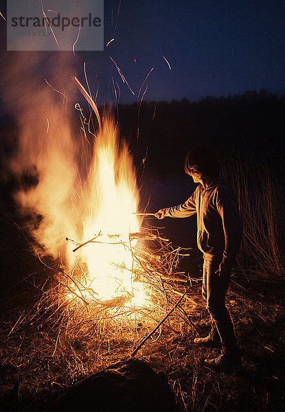 Junge am Lagerfeuer stehend