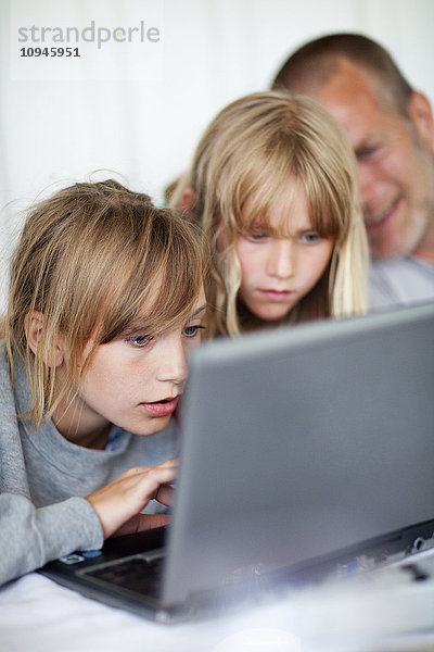 Mädchen mit Vater am Laptop