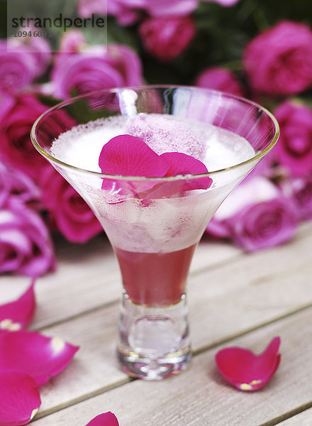 Cocktail mit Rosenblüte im Glas  Nahaufnahme
