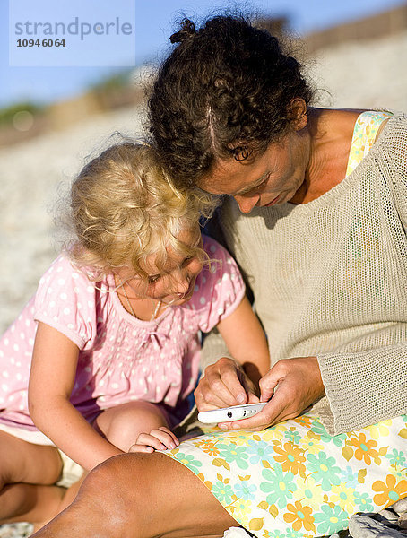 Mutter und Tochter tauschen Textnachrichten auf dem Mobiltelefon aus