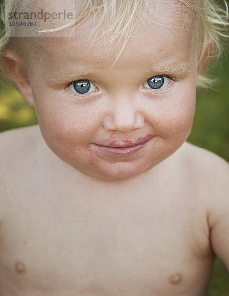 Junge mit Blaubeersaft im Gesicht  Nahaufnahme  Porträt