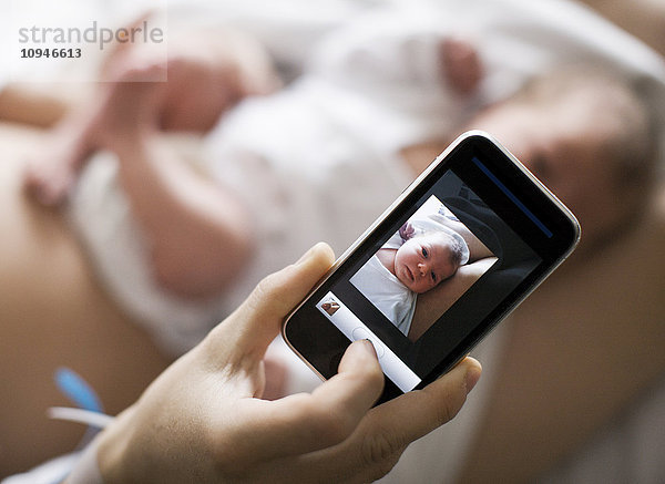 Mutter fotografiert ihr Baby mit dem Mobiltelefon