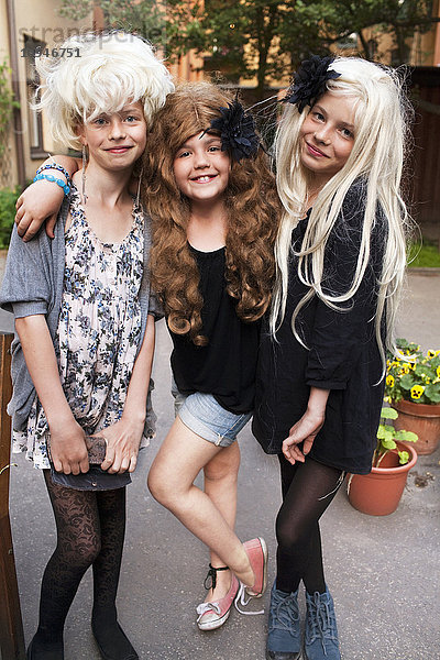 Porträt von drei Mädchen mit Perücken