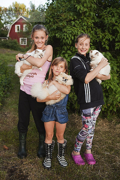 Porträt von drei Mädchen mit Haustieren