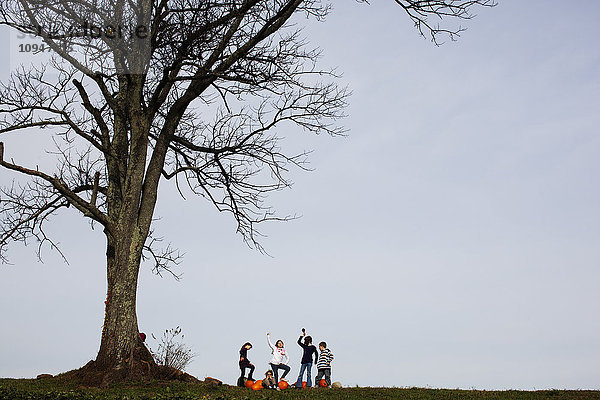 Fünf Kinder haben Spaß unter einem großen Baum