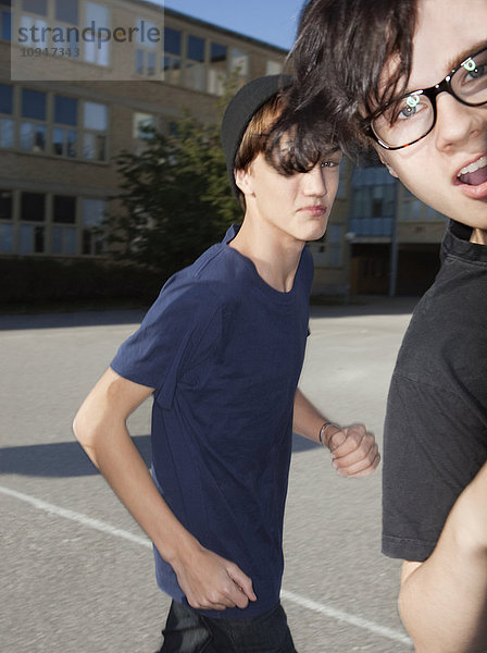 Zwei Jungen im Teenageralter spielen auf dem Schulhof