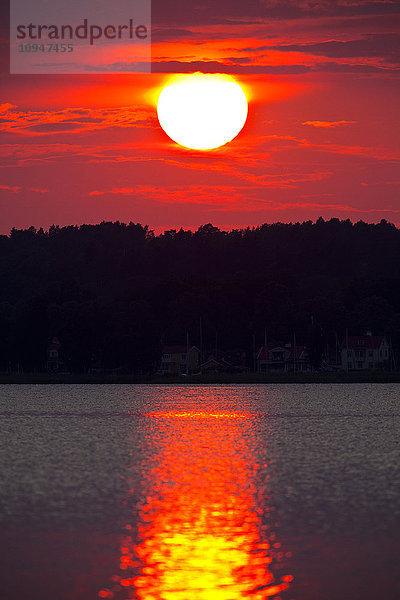 Rote Sonne  die sich bei Sonnenuntergang im Wasser spiegelt
